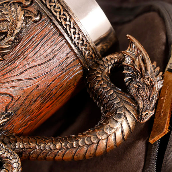 Macro close-up of the sculpted dragon head and scale handle on the classic bronze medieval barrel tankard, highlighting the intricate resin wood grain texture and braided rim details.