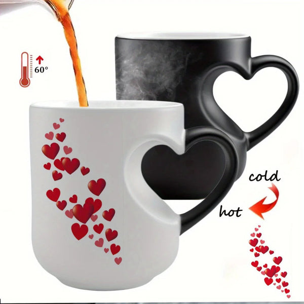A ceramic mug with a heart-shaped cutout handle, shown in both cold and hot states. The mug is white when cold, decorated with a cascade of red hearts, and turns black when hot, with steam rising.