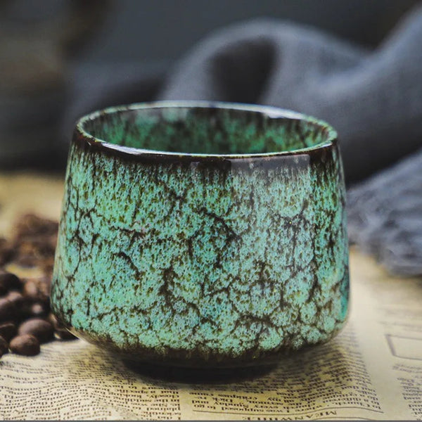 Modern minimalist ceramic tea cup in Forest Green with unique cracked moss reactive glaze.