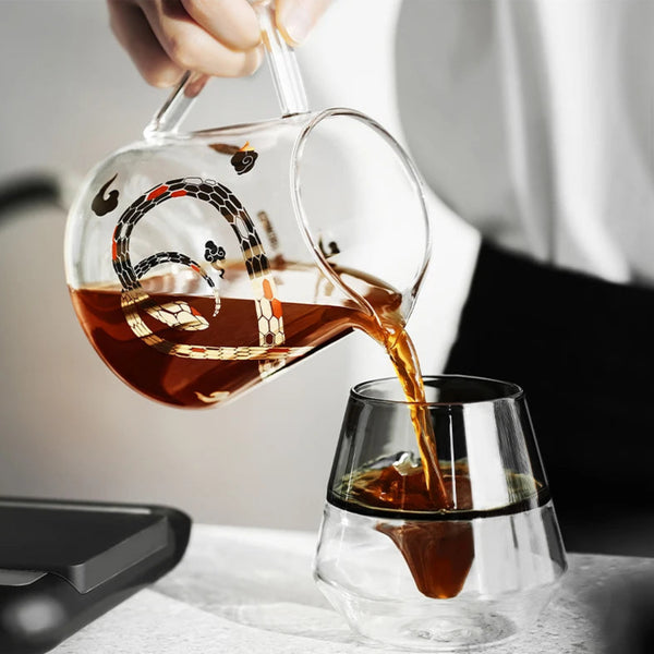 Barista pouring coffee from an MHW-3BOMBER Serpent Series Glass Server into a double-walled glass cup, showcasing the precision spout.