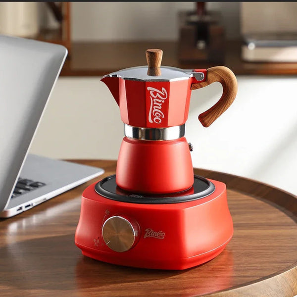 Red Bincoo coffee maker on a wooden table with a laptop in the background, featuring the Bincoo logo and tagline