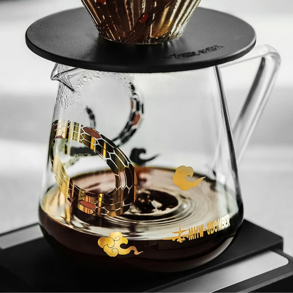 MHW-3BOMBER Serpent Series 500ml Coffee Server with gold snake decal, shown with a metal pour-over dripper on a digital coffee scale.