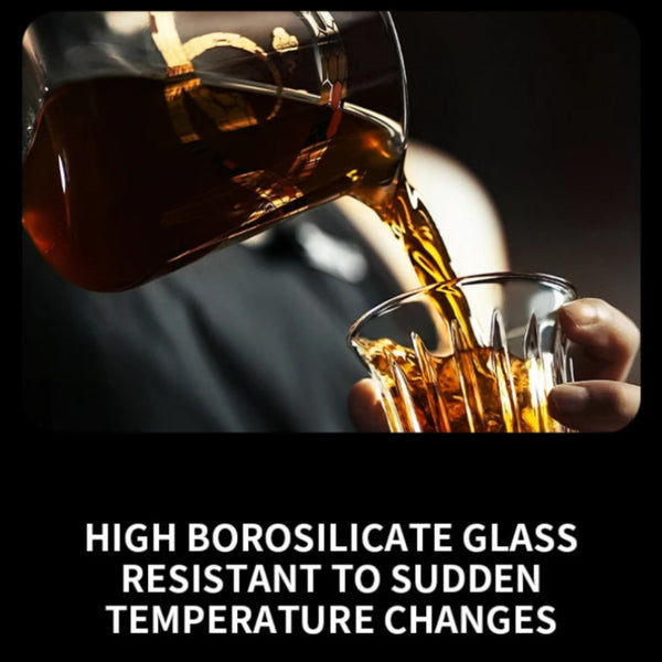 MHW-3BOMBER Serpent Series Coffee Server made of high borosilicate glass, showing a barista pouring hot coffee into a glass cup.