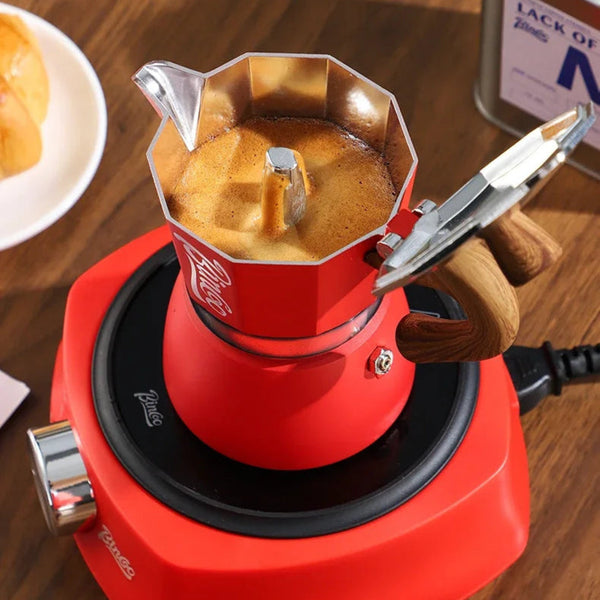 Red coffee maker with coffee being brewed on a wooden table, accompanied by text about mellow taste and home cafe.