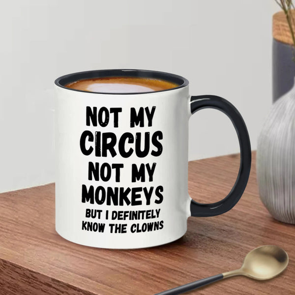Mug with text 'Not my circus, not my monkeys, but I definitely know the clowns' on a wooden surface.