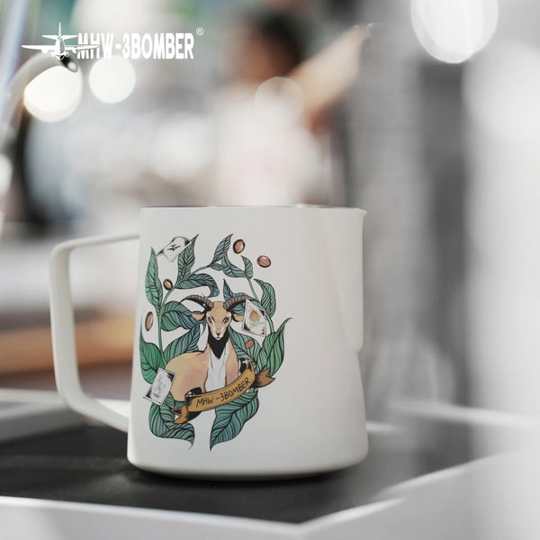 MHW-3BOMBER Origin Series white milk pitcher with Kaldi goat illustration on a clean, modern coffee bar.