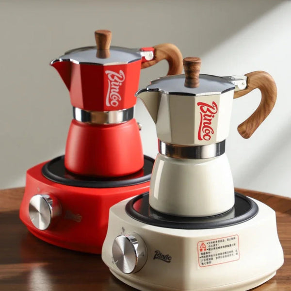 Two moka pots, one red and one white, on a wooden surface with a blurred background.